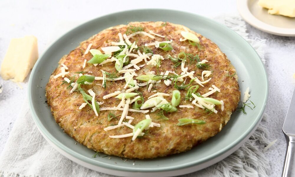 Galette di patate su piatto verde con formaggio ed erette