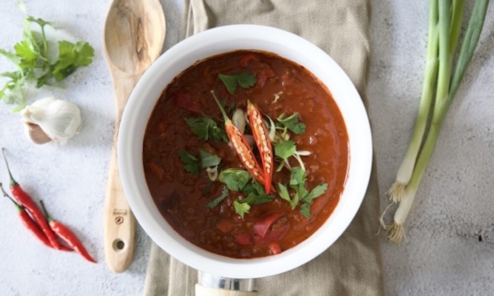 Chilli con carne guarnita con peperoncino e prezzemolo